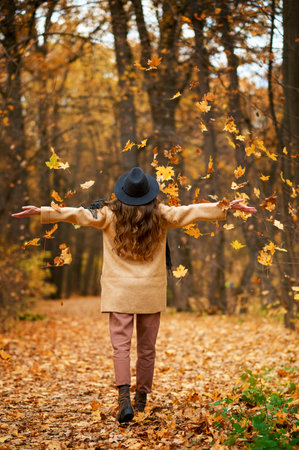 Happy excited young woman under leaves fallの写真素材