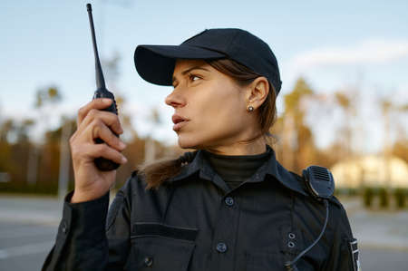 Portrait of female cop communicating on walkie-talkieの写真素材