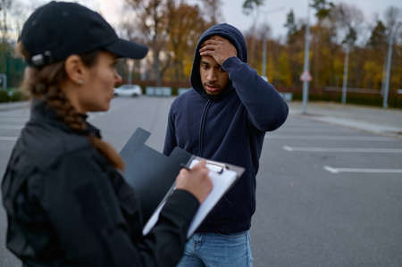Upset man and police woman issuing fineの写真素材