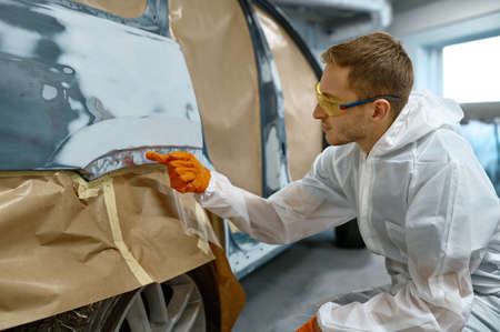 Repairman checking quality of old paint removalの写真素材