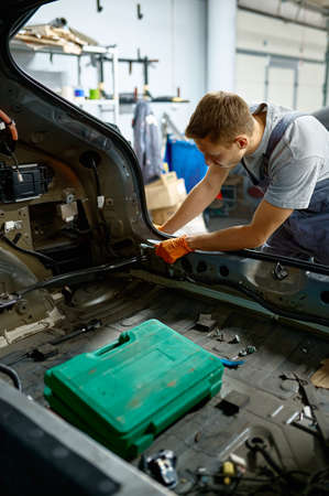 Workman fixing bolt during car body repairの写真素材
