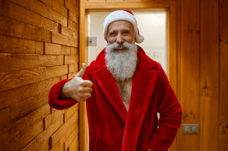 Santa Claus in red bathrobe in saunaの写真素材