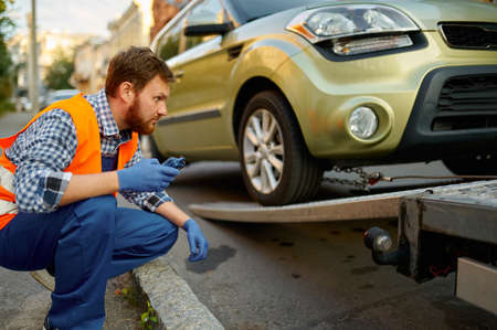Male road worker monitoring car loading processの写真素材