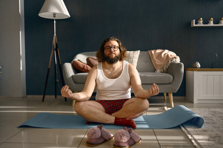 Funny fatty man meditating practicing home yogaの写真素材