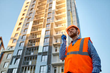 Builder worker using walkie-talkie on construction siteの写真素材