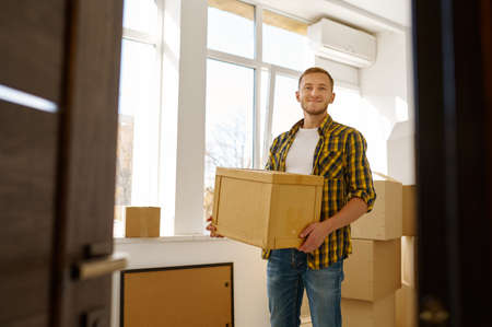 Young man carrying cardboard box during relocationの写真素材