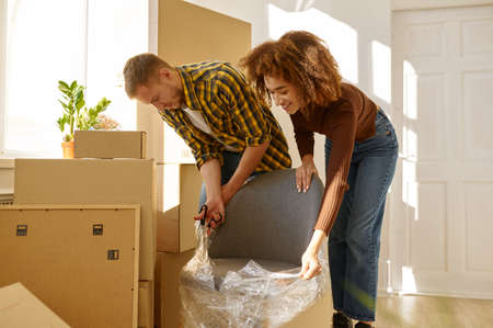 Smiling couple unpacking furniture in new homeの写真素材