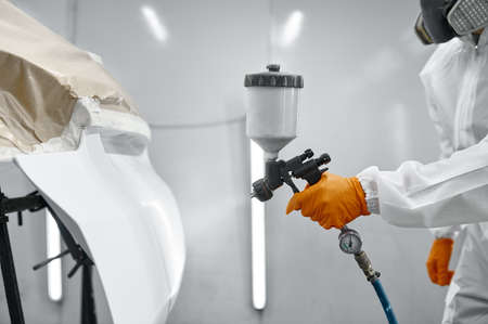 Technician in safety clothing spraying car paintの写真素材