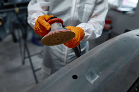 Closeup auto mechanic hands with orbital polisher