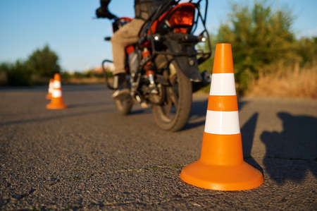 Student on motorbike, snake riding between conesの写真素材