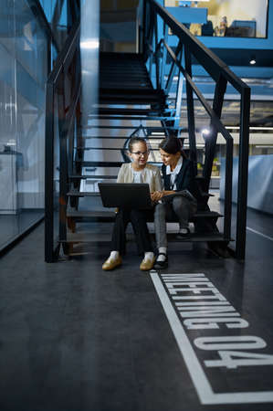 Two business children working together on stairs