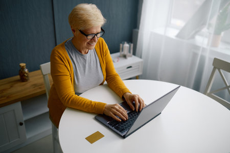 Mature woman doing online payment on laptop