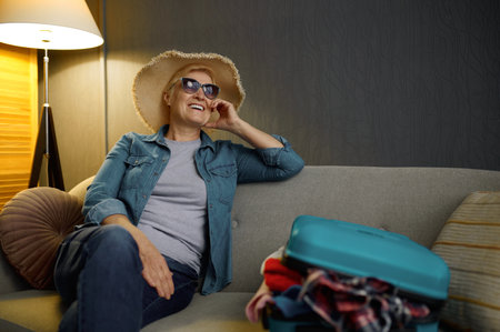Senior woman with packed luggage for journeyの写真素材