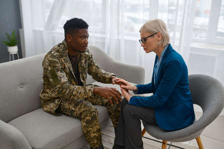 Psychologist giving support to soldier during therapyの写真素材