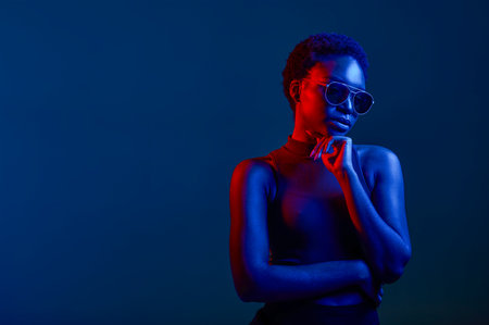 Pensive woman in sunglasses over dark backgroundの写真素材