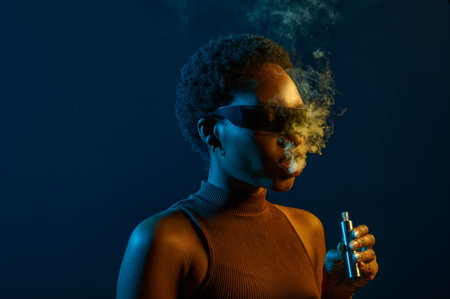 Portrait of woman in eyeglasses smoking vapeの写真素材
