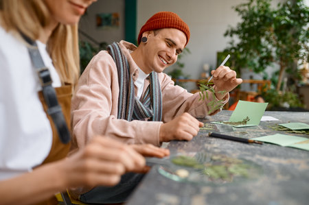 Creative artist making herbarium composition sitting at deskの写真素材