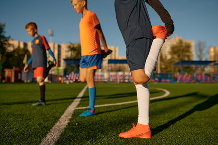 Young boys football players doing warm up workout stretching legsの写真素材
