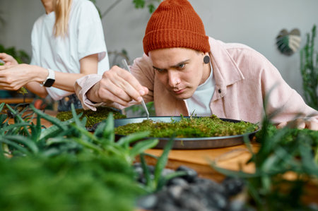 Experienced male florist working on circle plant panel closeupの写真素材