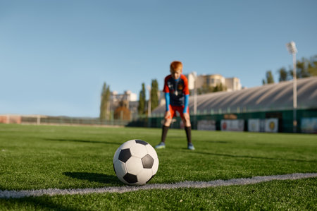 Boy football player looking at soccer ball before to kickの写真素材