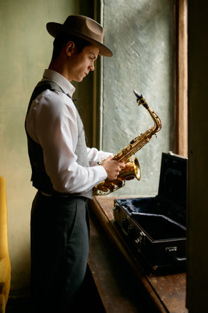 Young musician putting saxophone into case after practicingの写真素材