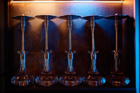 Row of hookahs with glass bulbs on display at market for sale