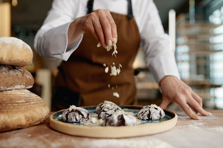 Baker chef sprinkling freshly baked oatmeal cookies with cerealsの写真素材