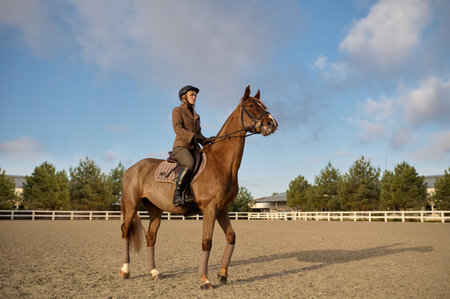 A horse trainer with her stallion outdoors in farmの写真素材