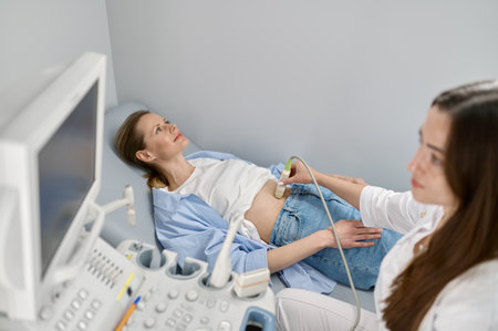 Professional doctor examining his patient doing abdominal ultrasoundの写真素材