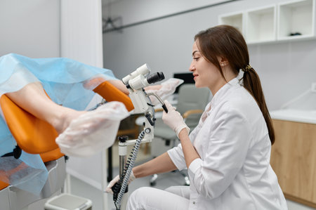 Gynecologist examining patient on chair with gynecological microscopeの写真素材