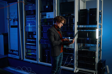IT technician using digital tablet while working in data center with server rackの写真素材