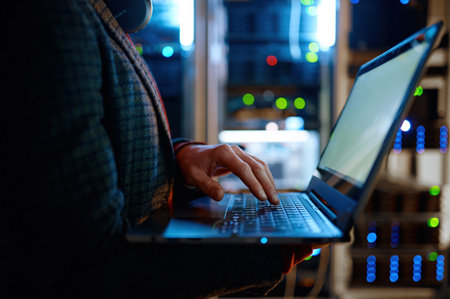 IT technician checking the servers vitals using laptop computerの写真素材