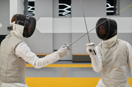Fencing partners fighting with rapiers practicing attack and defense combination