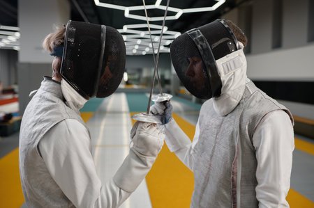 Two fencers crossed swords before fight, closeup shot of fencing dual startの写真素材