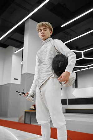 Teenage boy fencer wearing uniform and holding sword portrait