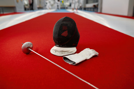 Fencing sword, protective helmet with mask and leather glovesの写真素材