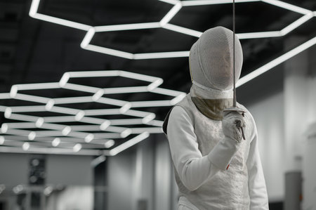 Sword sport athlete portrait wearing protective clothes and helmet at trainingの写真素材