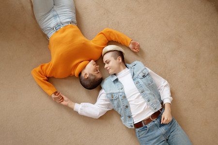 Top view of romantic loving lesbian woman couple lying face to face on floor