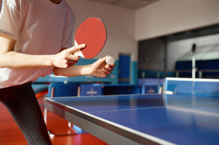 Closeup view of adult woman playing table tennis in gymの写真素材