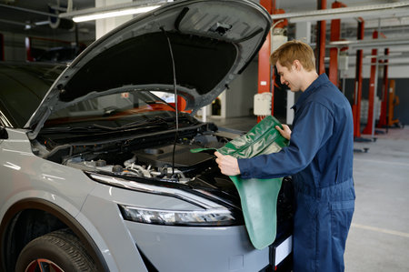 Male mechanic using protective cape for work in engine repair service