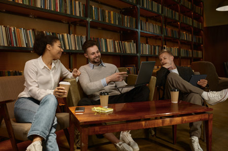 Multiracial business freelance team chatting during coffee break in office