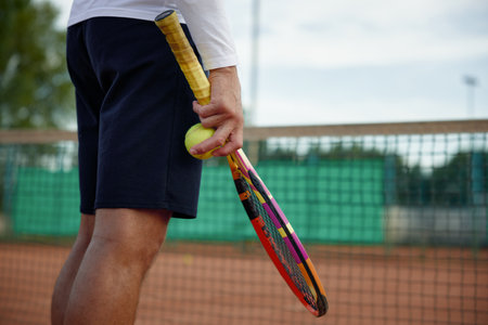 Closeup view on tennis racket and ball in hand on sportsmanの写真素材