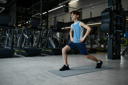 Teenager sport boy doing training fitness exercise at modern gymの写真素材