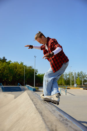 Teenager guy with roller skates performing tricks outdoorsの写真素材