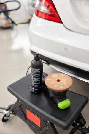 Bottle of special wax or polish cream and disk grinding machine