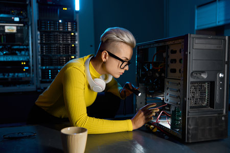 Young teenager hipster girl technician repairing computer part in datacenterの写真素材