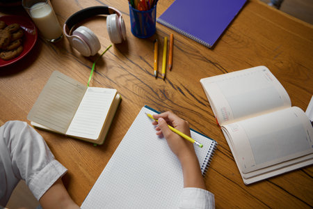 High angle view closeup on little student hands writing in copybookの写真素材