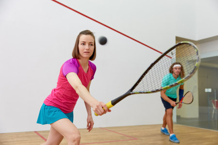 Young sportive couple practicing squash at indoor courtの写真素材