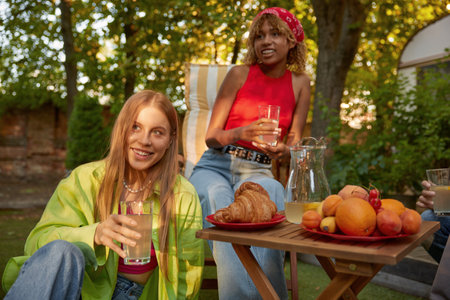 Young female friends at outdoor picnic celebrating summertime vacationの写真素材