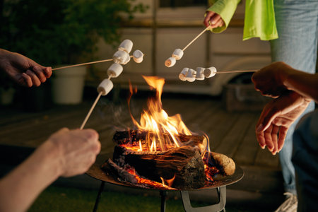 Closeup roasted marshmallows on skewers over open camping bonfireの写真素材